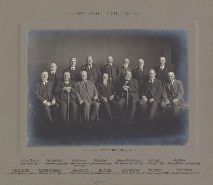 Group photograph of 'Pastoral Pioneers' with their name, property, age and number of 'years in North, thus ( _ )'. Back row (from left): Willie Dawes - Topar. Age 63 (45); Bob Coulthard - Tempe Downs. Age 68 (44); Joe Breaden - Todmorden & Henbury. Age 66 (48); Willie Wade - Panaramitee. Age 67 (60); Norman Richardson - Port Augusta West. Age 67 (51); W.G. Pryor - Saltia. Age 71 (48); John Murray - Yalata & Wallelberdina. Age 74 (56). Front row: Charlie Hirsch - Leighs Creek. Age 65 (50); Lachlan McTaggart - Wooltana. Age 69 (61); John Conrick - Nappa Merrie. Age 71 (52); Neil McGilp - Moolawatana. Age 79 (51); George Murray - Yalata. Age 72 (55); Tom Hogarth - Strangways Springs. Age 73 (41); Willie Ferguson - Baratta & Moolooloo. Age 73 (55).' State Library S.A.