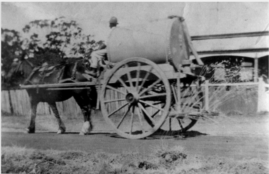 Horse drawn water tanker spraying the streets