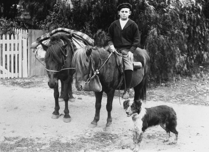 Lance Lewis on horseback with pack pony and dog