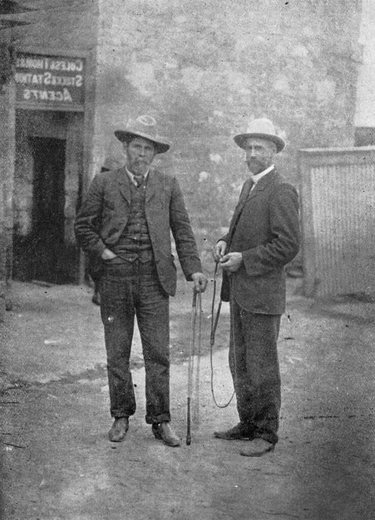 Sidney Kidman (left) and J. R. Chisholm photographed holding stock whips. State Library of QLD.