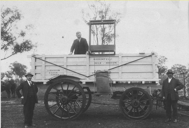 'First bulk wheat wagon built and used at Finley for 1922 harvest. Built by John Grinham for Lorenzo Marantelli (standing at right of picture). It was lifted by a hoist on to a conventional wagon. Note the device for elevation - unsewn cornsack filled with wheat to the tipping platform - Finley, NSW.' State Library NSW